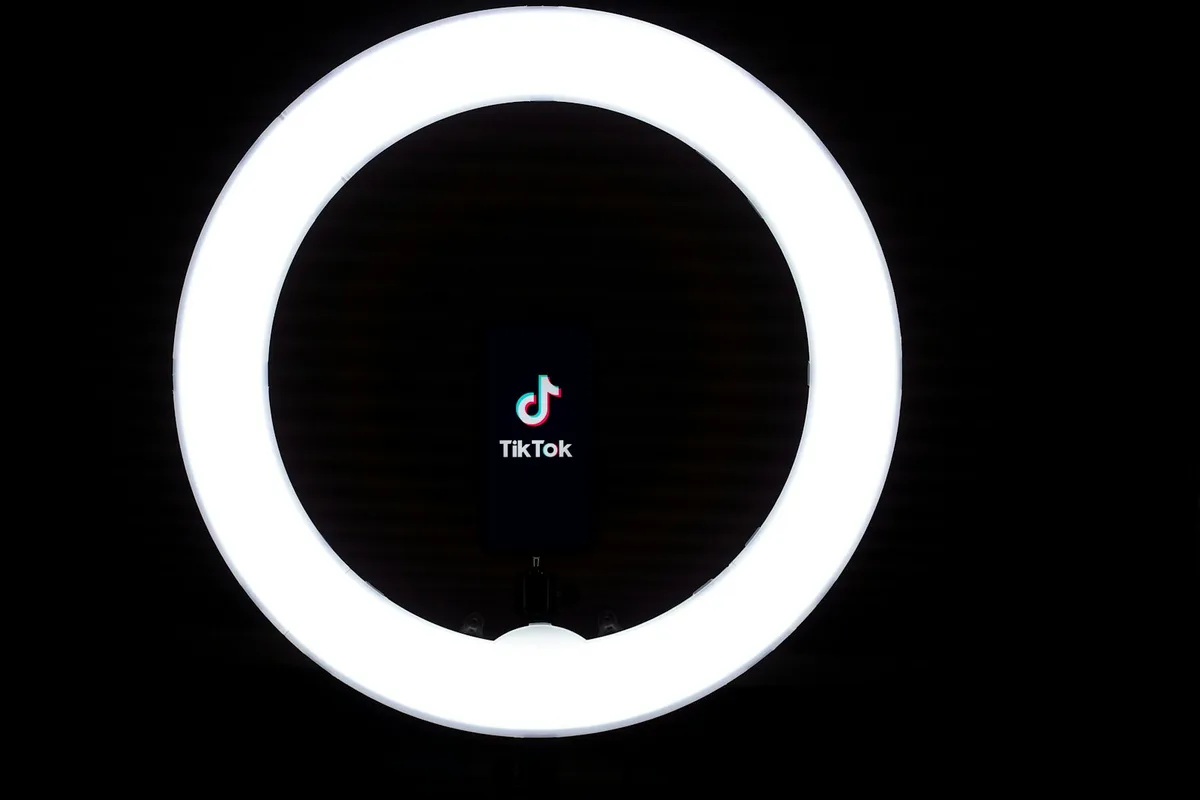 Round white and black ring light with reflective surface and studio background