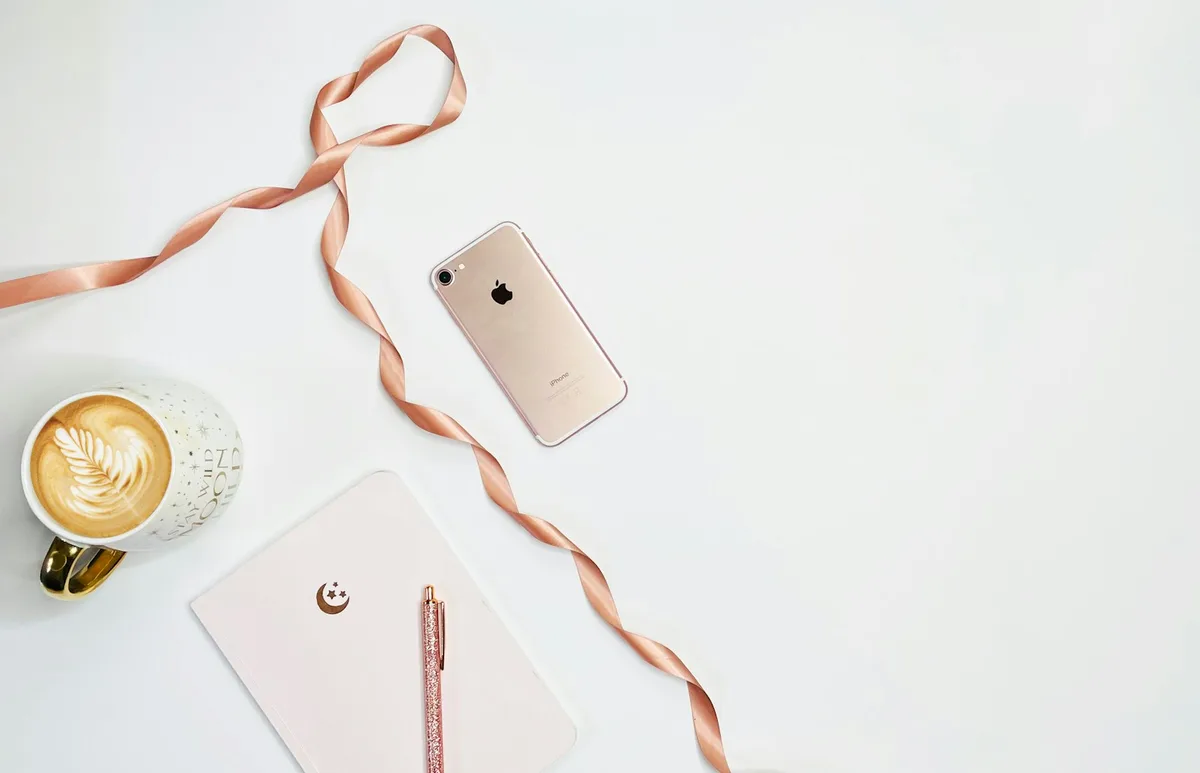 Silver iPhone lying face-down on a plain white surface